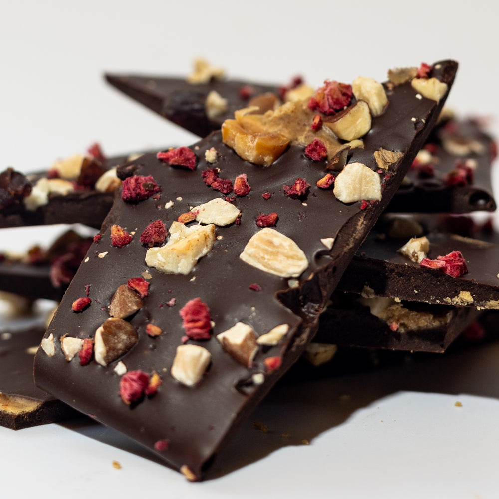 
                  
                     Close-up of no sugar added chocolate bark with visible roasted hazelnuts, almonds, dried cherries, and raspberries - Viva Cacao!
                  
                