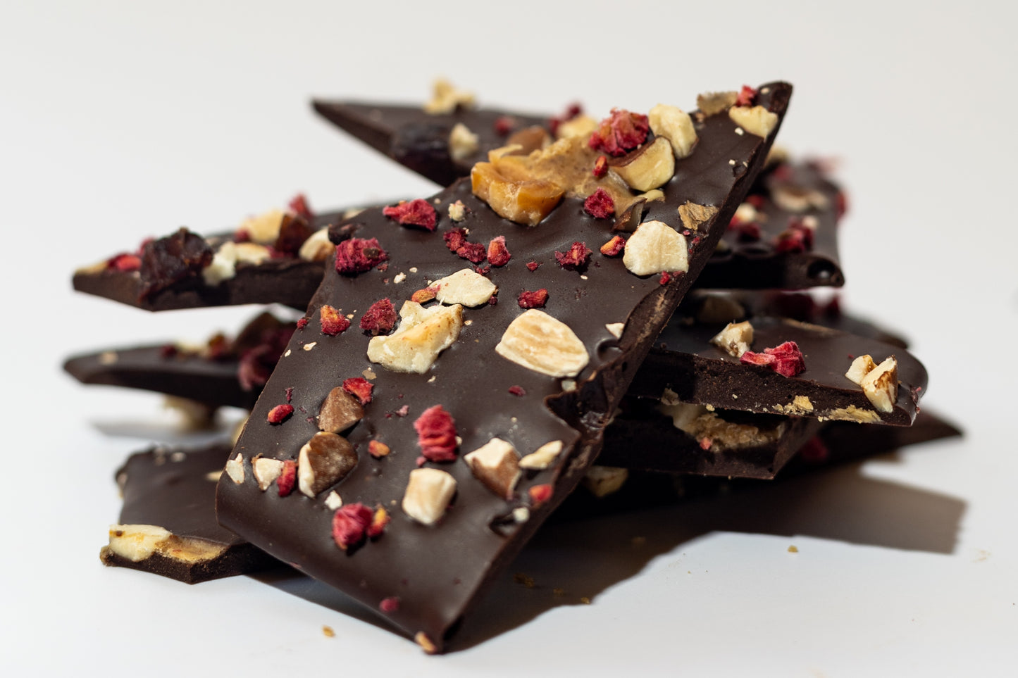 
                  
                     Close-up of no sugar added chocolate bark with visible roasted hazelnuts, almonds, dried cherries, and raspberries - Viva Cacao!
                  
                